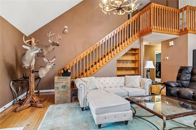 living room with hardwood / wood-style flooring, high vaulted ceiling, and a chandelier