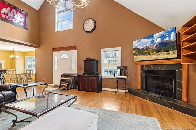 living room with hardwood / wood-style flooring, a tile fireplace, and a healthy amount of sunlight