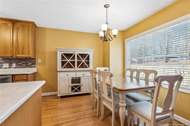 dining area featuring light hardwood / wood-style flooring and a notable chandelier