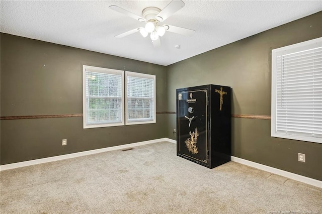 carpeted spare room with ceiling fan and a textured ceiling