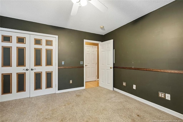 unfurnished bedroom with ceiling fan, light colored carpet, a textured ceiling, and a closet