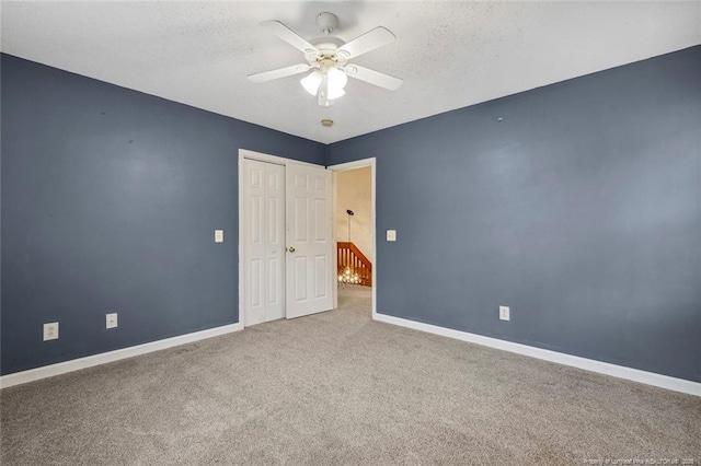 spare room with carpet flooring, a textured ceiling, and ceiling fan