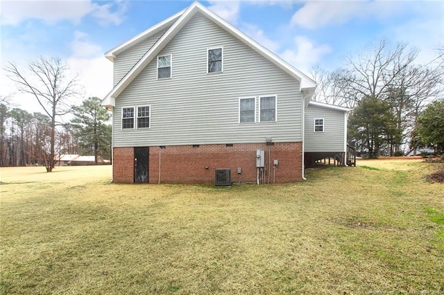 back of house with a yard and central air condition unit