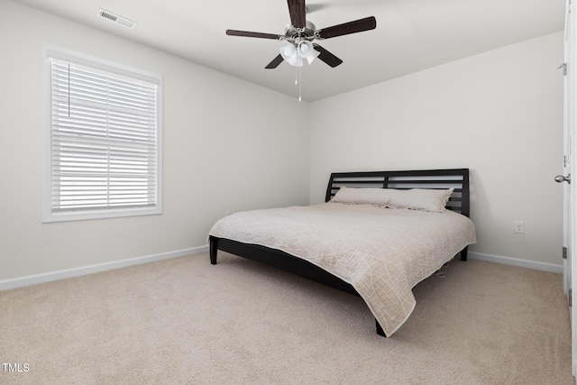 carpeted bedroom featuring ceiling fan, visible vents, and baseboards