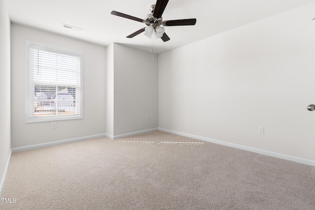 unfurnished room with light carpet, visible vents, baseboards, and a ceiling fan