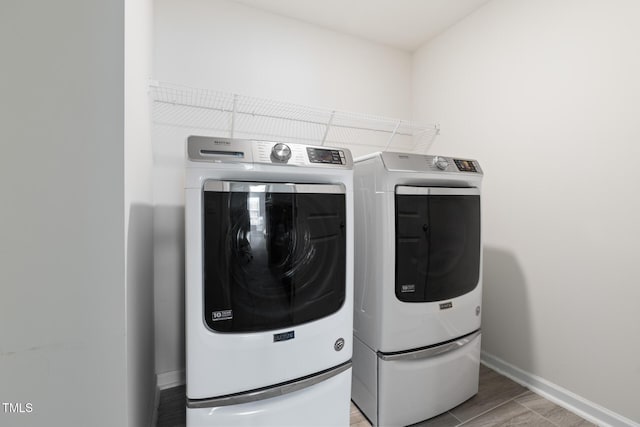 washroom with laundry area, independent washer and dryer, and baseboards