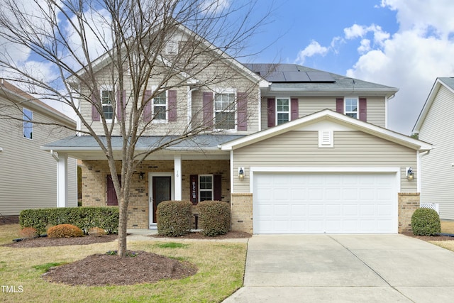 view of front of house with driveway, roof mounted solar panels, covered porch, a garage, and brick siding