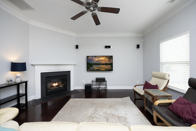 living room featuring a fireplace with flush hearth, crown molding, dark wood-type flooring, and baseboards