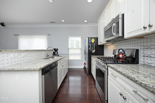 kitchen featuring a sink, stainless steel appliances, decorative backsplash, and crown molding