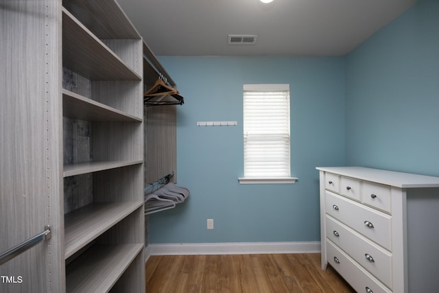 walk in closet with visible vents and wood finished floors