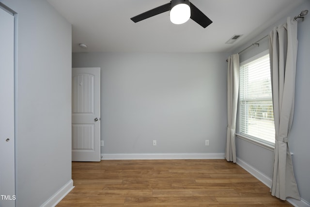 unfurnished room with light wood-style flooring, baseboards, visible vents, and ceiling fan