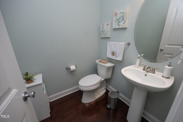 bathroom featuring toilet, wood finished floors, and baseboards