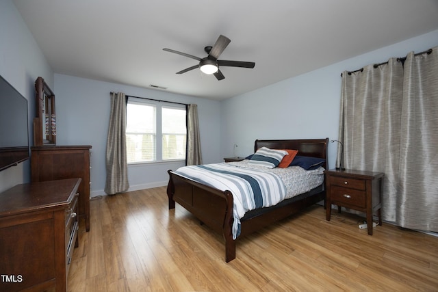 bedroom with visible vents, baseboards, ceiling fan, and light wood finished floors