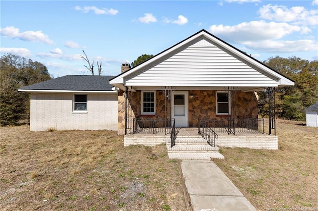 view of front facade featuring covered porch and a front yard