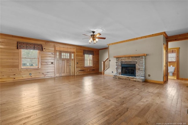 526 Grimble Dr, Linden, NC 28356 - unfurnished living room with wooden walls, a fireplace, ornamental molding, ceiling fan, and light hardwood / wood-style flooring