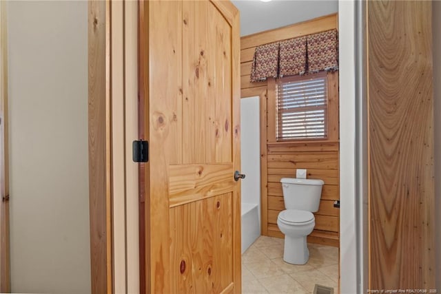 526 Grimble Dr, Linden, NC 28356 - bathroom with a washtub, wooden walls, tile patterned floors, and toilet