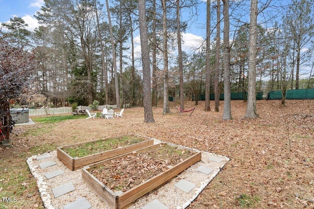 view of yard featuring fence and a vegetable garden