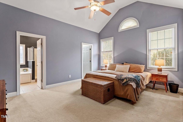 bedroom featuring light carpet, multiple windows, and ensuite bathroom