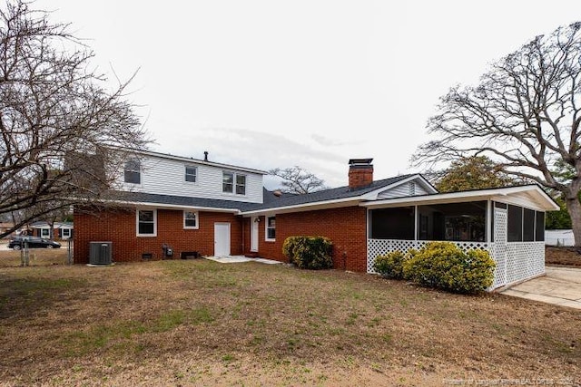 exterior space featuring central AC unit, a sunroom, and a front yard