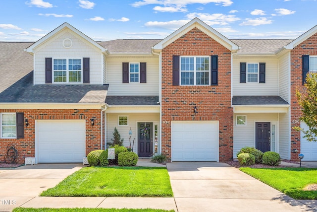 view of property with driveway, a garage, and brick siding