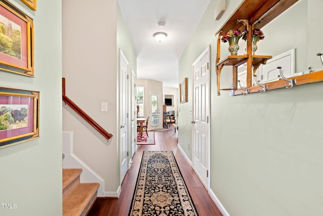 hall featuring stairway, wood finished floors, and baseboards