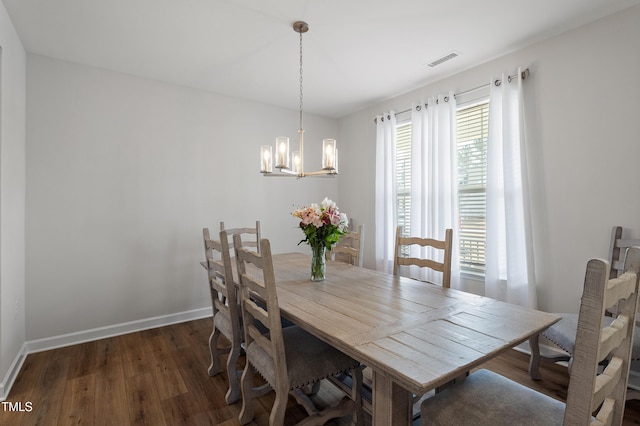 dining room featuring baseboards, visible vents, an inviting chandelier, and wood finished floors