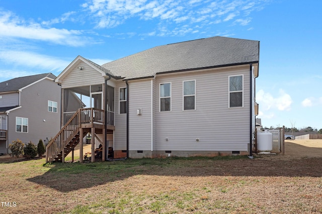 back of house with a lawn, a sunroom, roof with shingles, crawl space, and stairs