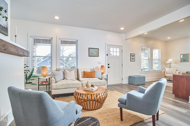 living room featuring light wood-type flooring and beamed ceiling