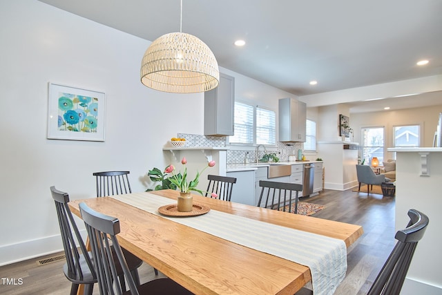 dining area with dark hardwood / wood-style flooring, a notable chandelier, and sink