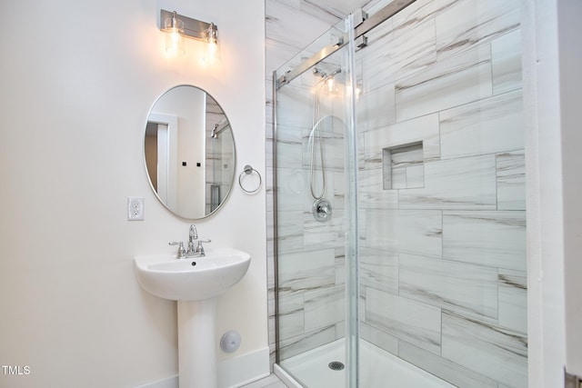 bathroom with a shower with door and sink