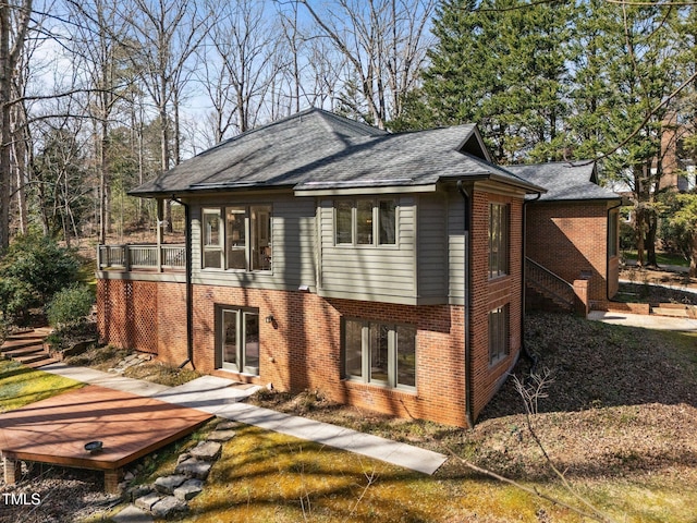 view of front of house featuring a shingled roof and brick siding