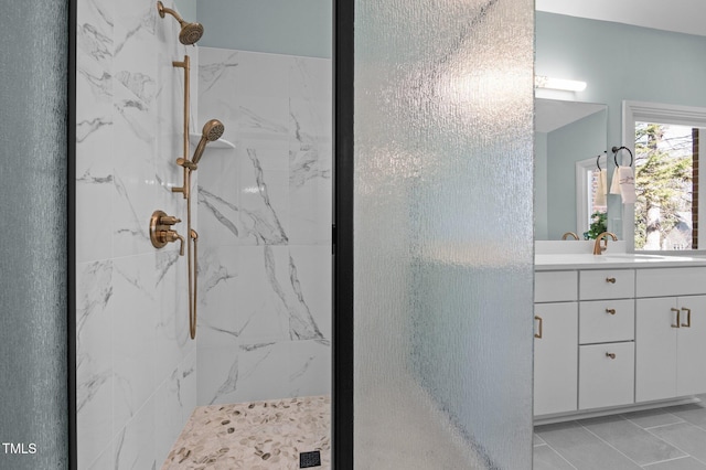 bathroom featuring a marble finish shower and vanity