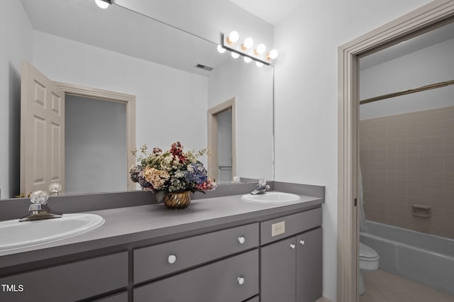 full bathroom featuring toilet, double vanity, visible vents, and a sink