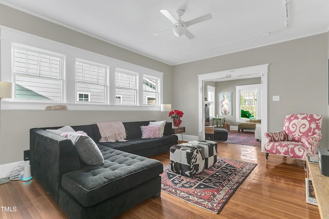 living room featuring baseboards, a ceiling fan, and wood finished floors