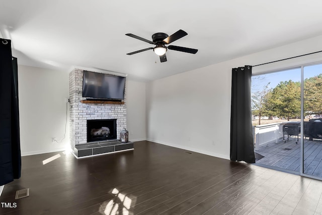 unfurnished living room with ceiling fan, hardwood / wood-style floors, and a brick fireplace