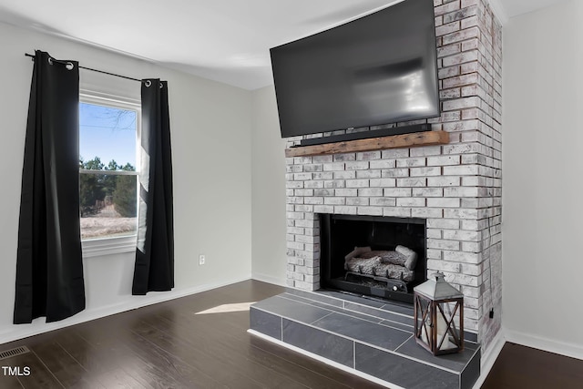 interior details featuring hardwood / wood-style flooring and a brick fireplace