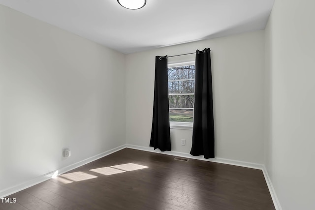 empty room with dark hardwood / wood-style flooring