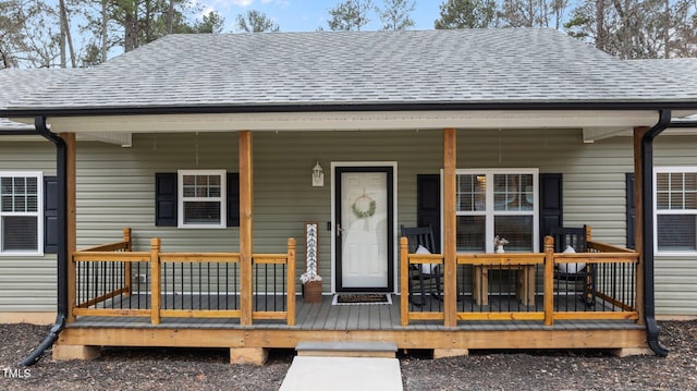 view of front of property with a porch and roof with shingles