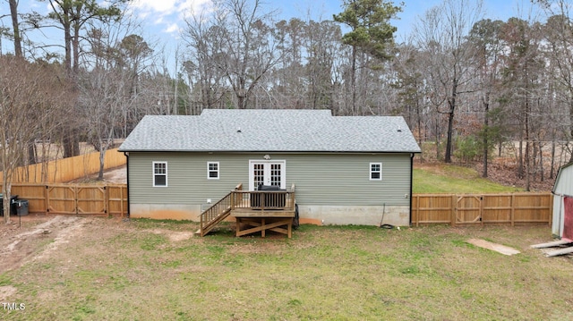 rear view of house featuring a yard, a shingled roof, a fenced backyard, and a gate