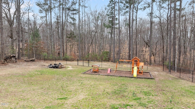 view of yard featuring playground community and fence