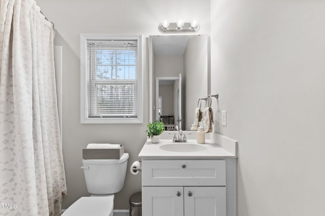 bathroom featuring curtained shower, vanity, and toilet