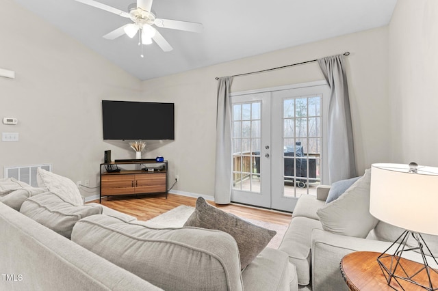 living room featuring visible vents, baseboards, lofted ceiling, french doors, and light wood-type flooring