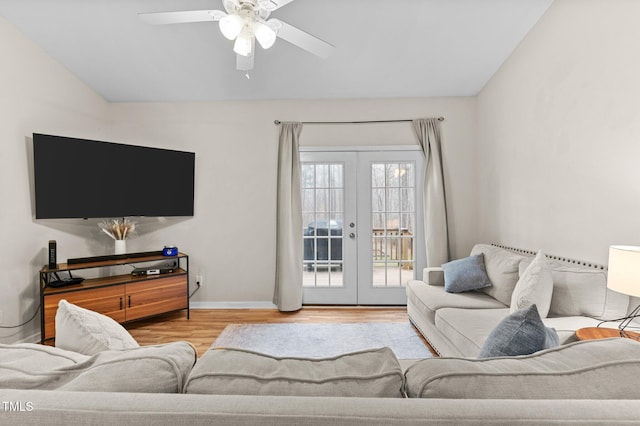 living room featuring french doors, lofted ceiling, light wood-style flooring, a ceiling fan, and baseboards