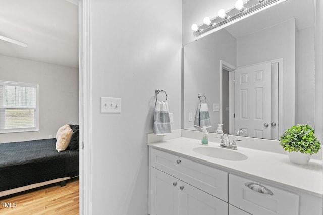 bathroom featuring wood finished floors, vanity, and ensuite bathroom