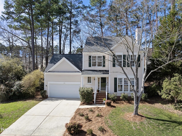 view of front of house featuring a garage, driveway, a chimney, and a front yard