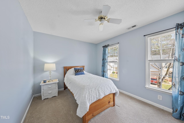 bedroom featuring carpet floors, visible vents, a textured ceiling, and baseboards