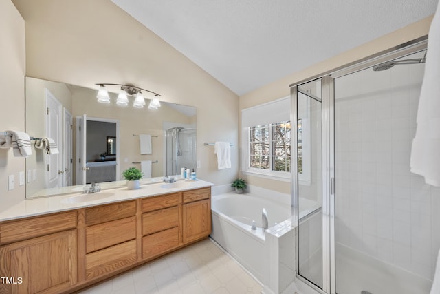 full bathroom featuring lofted ceiling, a garden tub, a sink, double vanity, and a stall shower