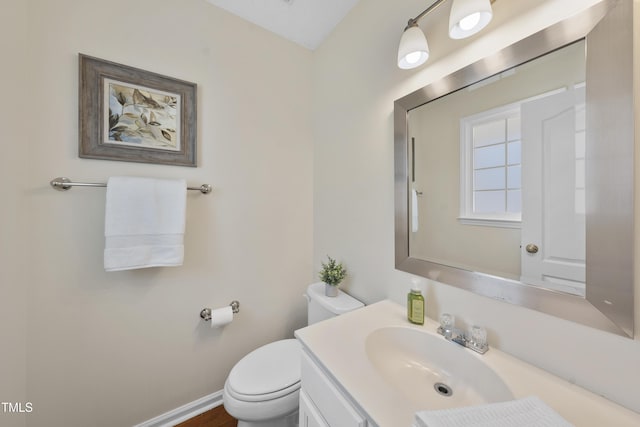 bathroom with vanity, toilet, and baseboards