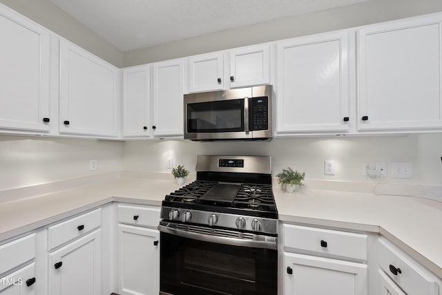 kitchen featuring light countertops, appliances with stainless steel finishes, and white cabinets