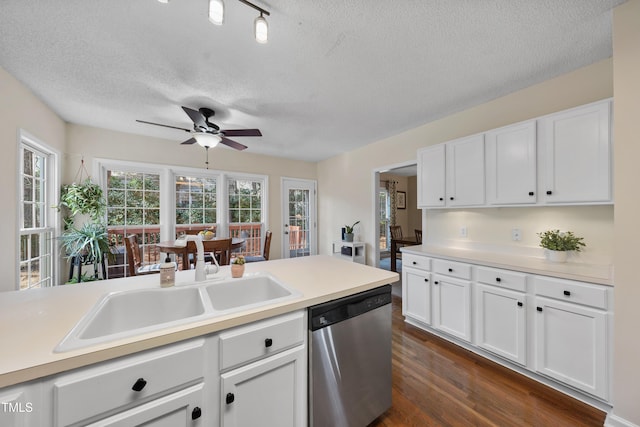 kitchen featuring dark wood-style flooring, a sink, white cabinets, light countertops, and stainless steel dishwasher